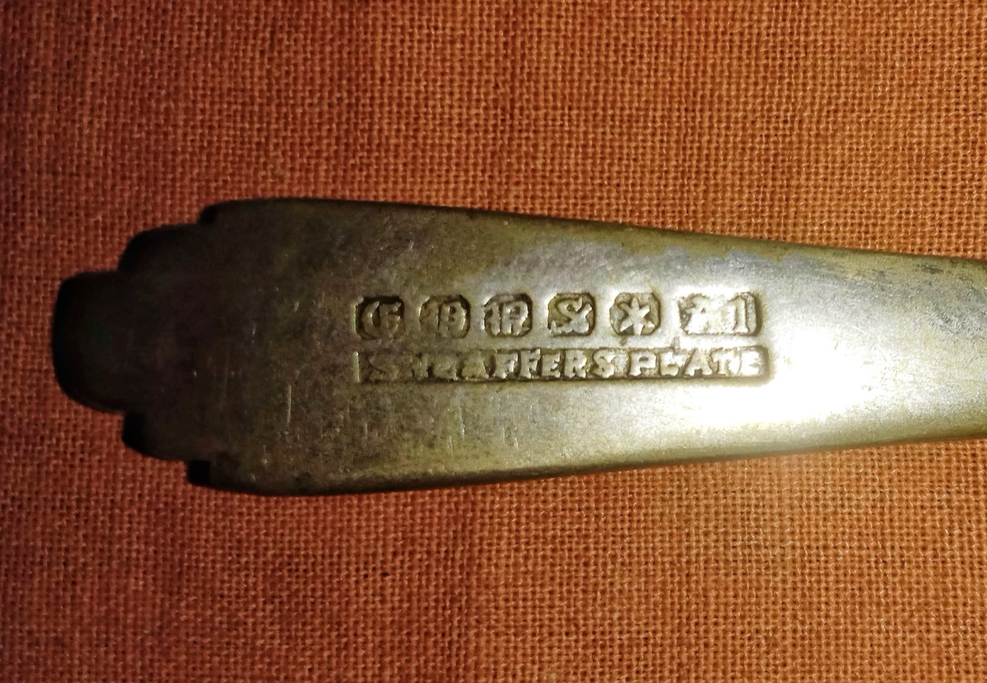 Multiple hallmarks struck on the reverse of an antique colonial-era silver spoon photographed in West Bengal, India