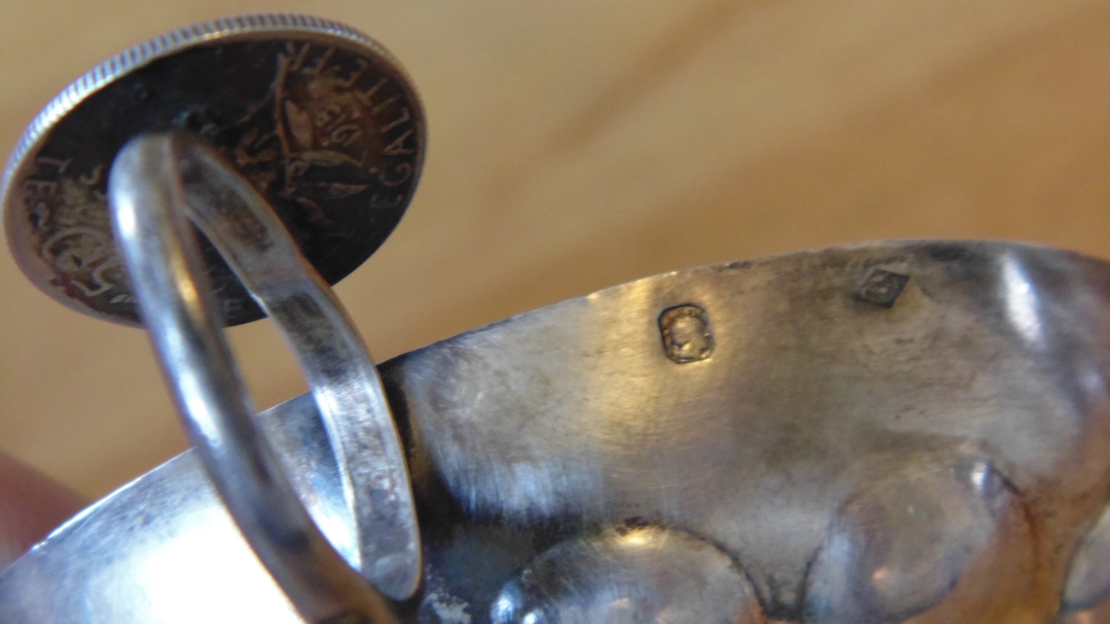 Close-up of the French Minerva head hallmark stamped on a silver wine-tasting tastevin, indicating 950 first-standard silver