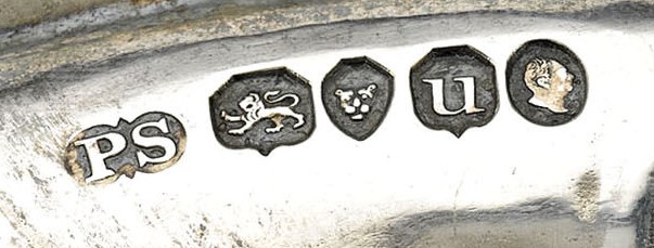 Close-up photograph of a five-mark British silver hallmark set by Paul Storr, 1835: sovereign's head duty mark, date letter, London leopard's head town mark, lion passant standard mark, and PS maker's mark